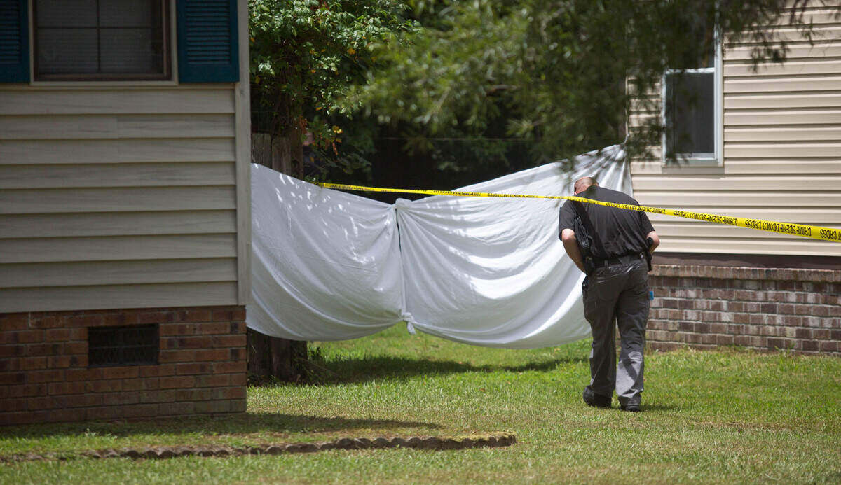 Horry County police officers block off a backyard area of a home located on Reef Road while investigating a death in the Socastee area on July 6.