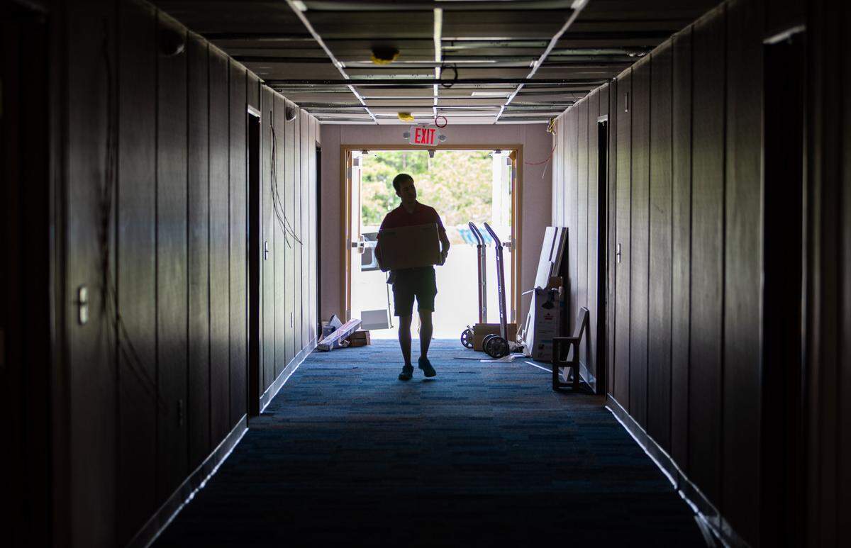 Horry County Schools technology employee John Dolley carries a new projector into a modular building as crews work to ready modular classrooms at St. James High School in Murrells Inlet, for the 2019 school year.