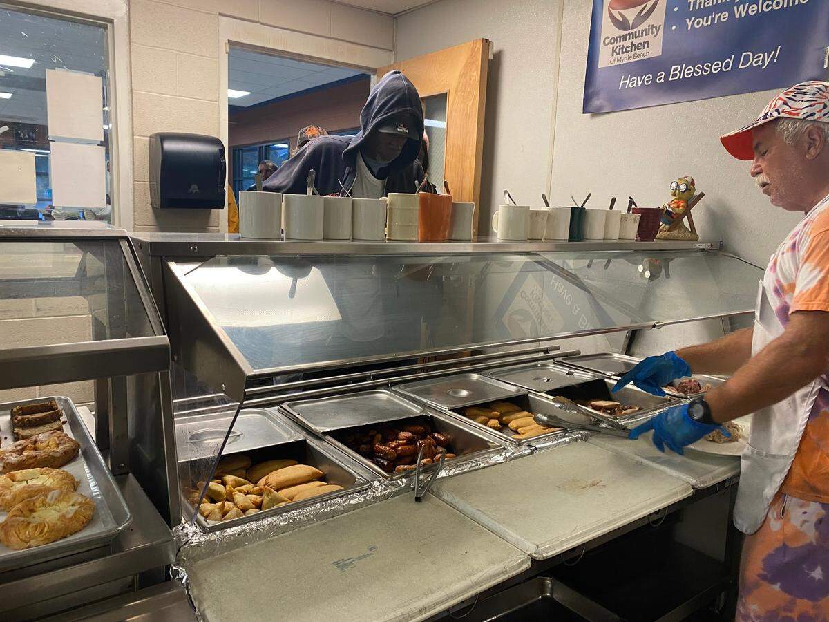 Doug Beasley, a volunteer at the Community Kitchen, serves breakfast Friday morning. The kitchen will be open through lunch due to Hurricane Ian’s expected impact on SC coasts. September 30, 2022.