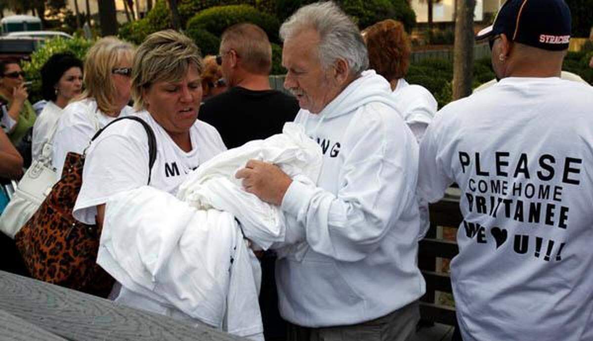 Brittanee Drexel’s grandfather Al Wagner (center) hands out T-shirts with a photo of the missing New York teenager Friday evening at Hurl Rock State Park in Myrtle Beach. Photo By Randall Hill rhill@thesunnews.com