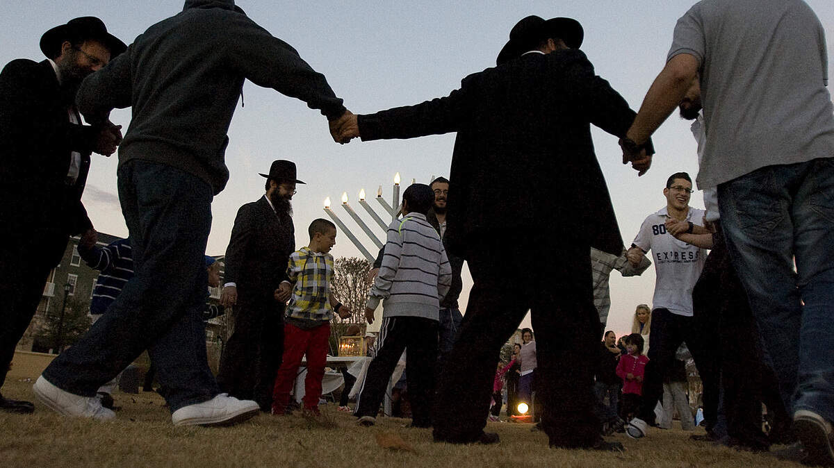 After the candles are lit, men and boys join hands as they dance in a circle at The Market Common in Myrtle Beach on Monday, Dec. 10, 2012. The Chabad Jewish Center of Myrtle Beach joined in the lighting of the third candle in the eight-day Hanukkah festival. In addition to dancing and lighting of the menorahs, music was played, children joined in games and a pair performed with fire. Photo by Janet Blackmon Morgan / jblackmon@thesunnews.com