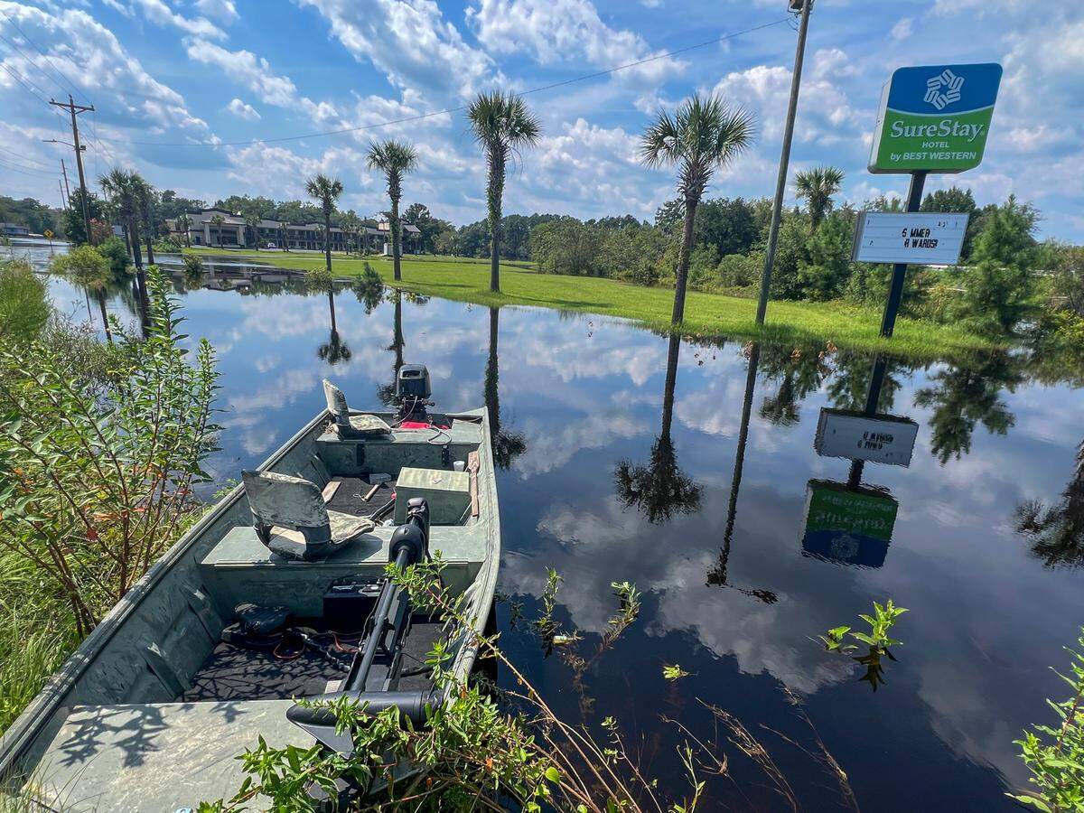 A boat is pulled alongside Waccamaw Drive near the Sure Stay Hotel at Savannah Bluff in Conway where residents use boats to access their homes surrounded by flood waters. The Waccamaw River at Conway reached the major flood stage of over 14 feet on Friday following Tropical Storm Debby’s rains. The river is expected to crest this weekend. Aug. 16, 2024.