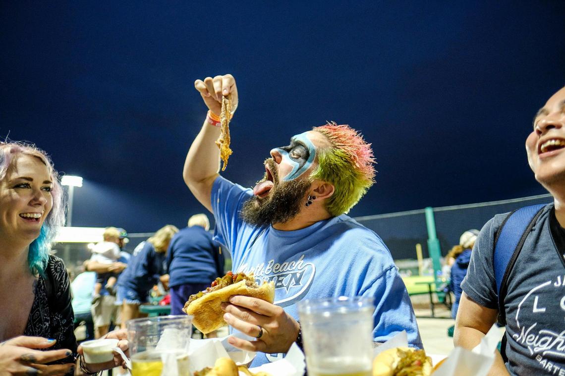 Brian Reynolds with hair and face colored in support of the Myrtle Beach Pelicans has a snack during the home opening game against the Augusta Green Jackets. The Myrtle Beach Pelicans played their first home game of the 2021 season Tuesday night against the Augusta Green Jackets. The Chicago Cubs Low Class A affiliate did not play in 2020 because of the coronavirus.. May 11, 2021.