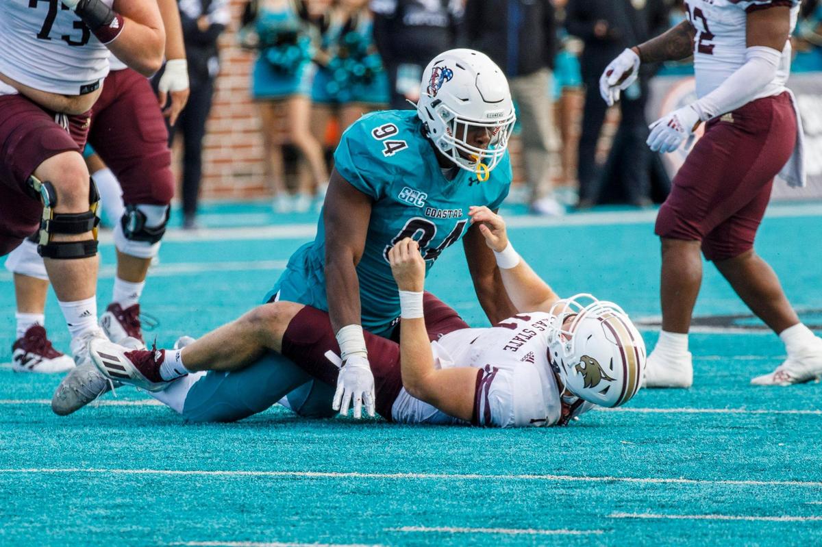 Coastal Carolina outside linebacker Jeffrey Gunter looks down on Texas State quarterback Tyler Vitt after a tackle that resulted in a late hit penalty against Gunter. The Chanticleers played the Texas State Bobcats in a Sun Belt Conference NCAA FBS college football game in Conway SC. Nov. 20, 2021.