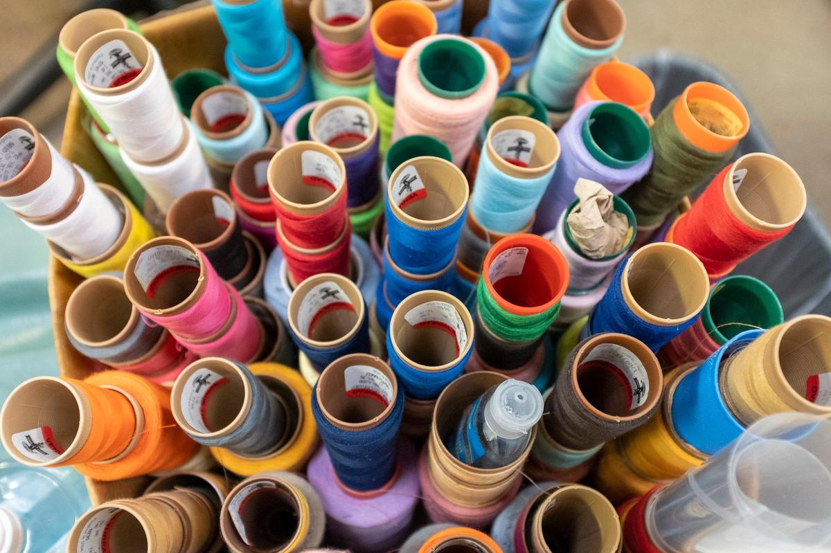 Spools of thread fill a container at the Tara Grinna swimsuit factory in Conway.