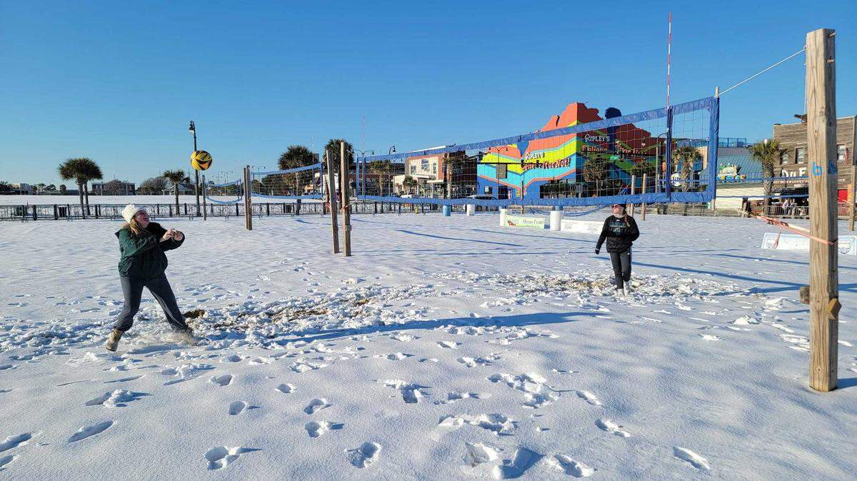 Students Madison Gallion and Catrina Edwards play volleyball in Plyler Park in the snow in downtown Myrtle Beach on Wednesday, Jan. 22, 2025.