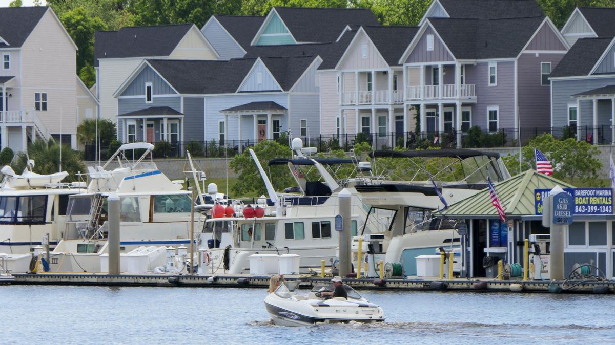 A boat on the Intracoastal Waterway passes the marina and cottages in North Myrtle Beach, South Carolina.