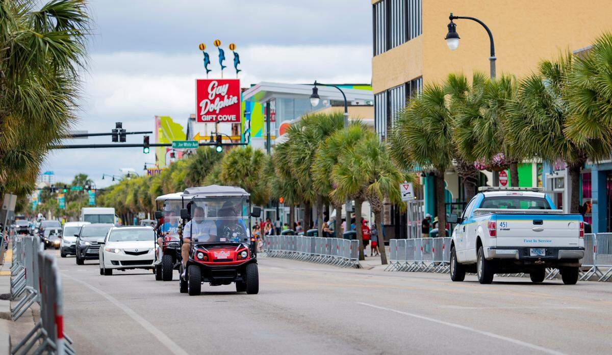 Golf carts drive along Ocean Boulevard Wednesday afternoon in Myrtle Beach amidst the coronavirus pandemic.