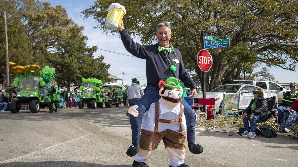 A man walks along with the parade as floats move along Main Street in North Myrtle Beach during the St. Patrick’s Day parade Saturday.