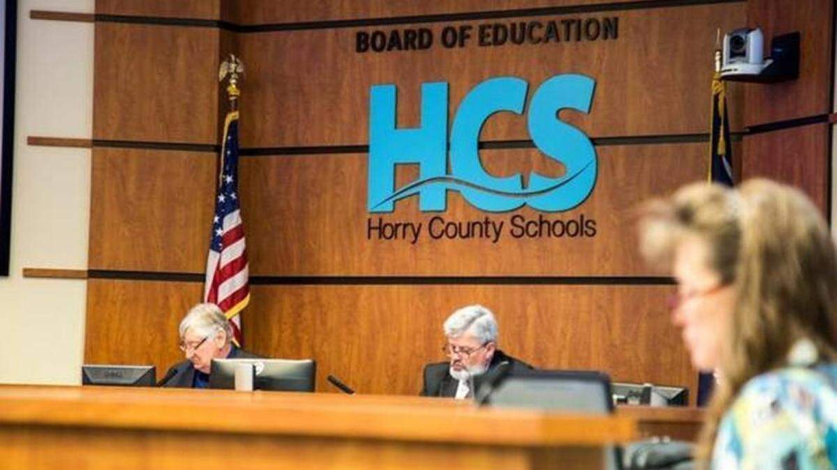 Horry County Schools Superintendent Rick Maxey (center) and school board Chairman Joe DeFeo (left) look over items on the agenda during a recent meeting.