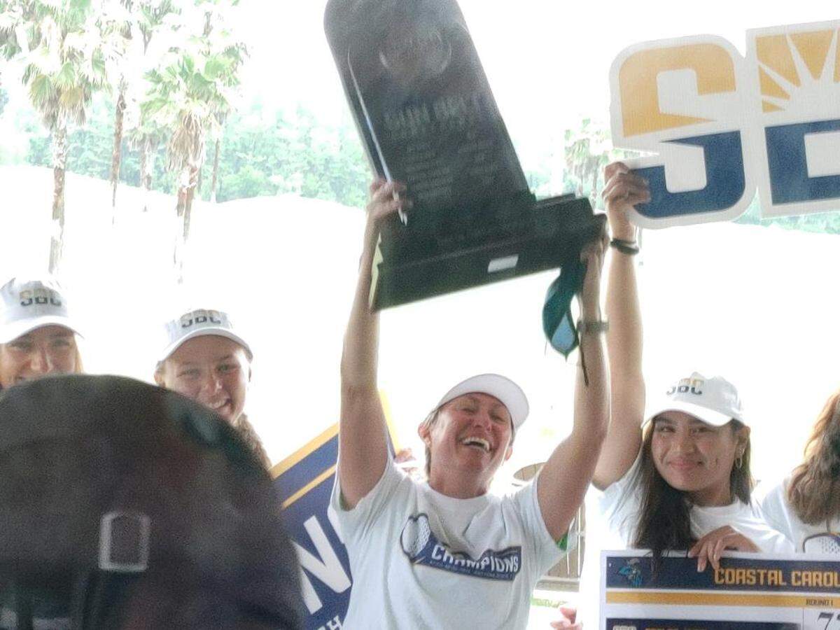 Coastal Carolina women’s golf coach Katie Quinney (center) celebrates with her team Tuesday after winning the Sun Belt Conference championship at LPGA International in Daytona Beach, Florida.