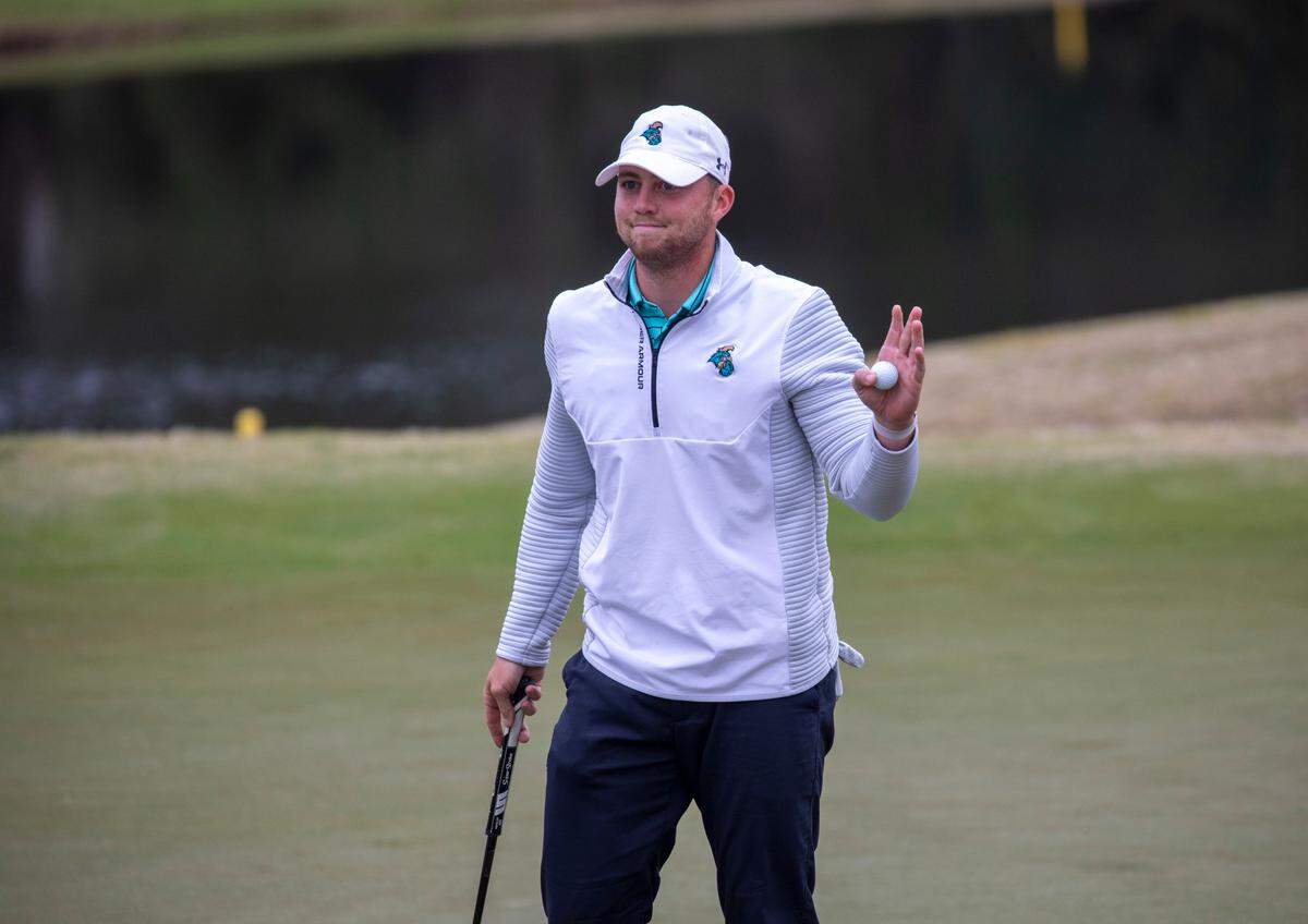 Coastal Carolina’s Zack Taylor waves to spectators as he finishes the 18th hole at The Dunes Club on Monday in the VI Sports General Hackler Championship golf tournament in Myrtle Beach, S.C. March 15, 2021.