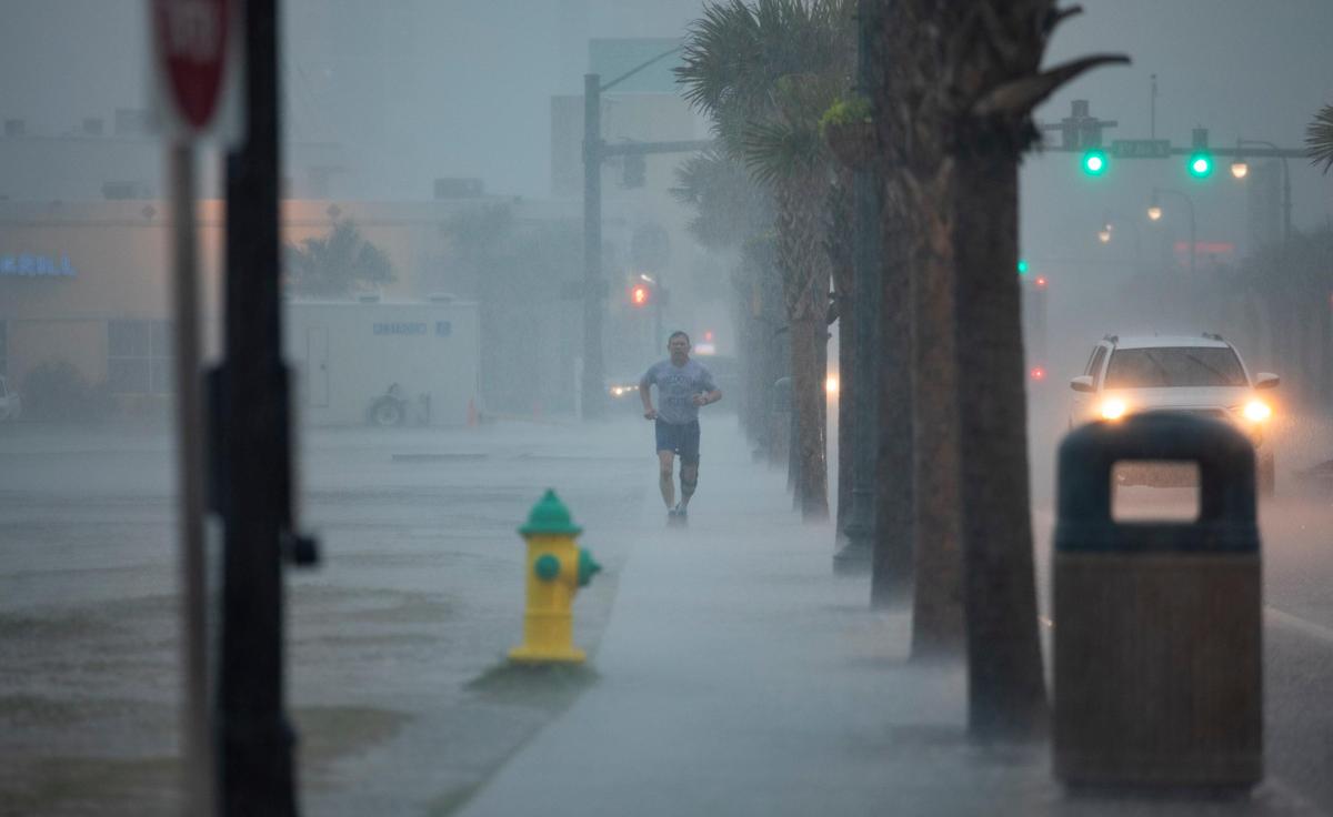 Daniel Parker of Fredonia, New York takes a jog along Ocean Boulevard in Myrtle Beach Friday morning despite heavy wind and rain throughout the area.