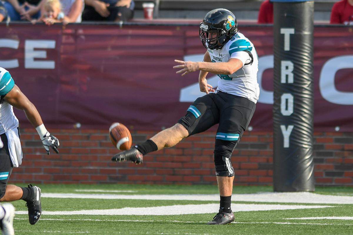 Coastal Carolina punter Charles Ouverson of Murrells Inlet punts against Troy in Sept. 2018. He is among the seniors or graduates who are returning to the program for the 2021 season.