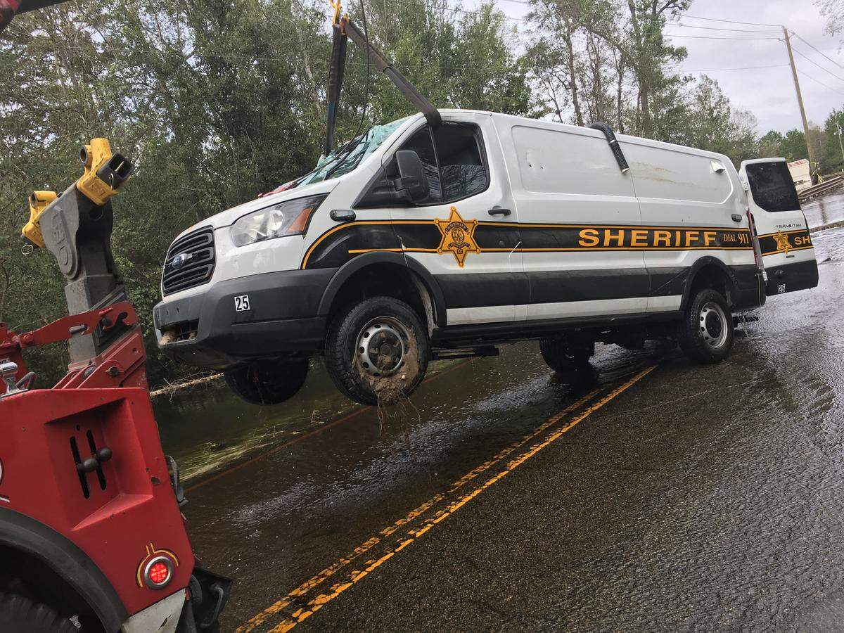 The Horry County Sheriff’s Office transport van is removed from the scene. Two mental health patients drown in the vehicle after it was swept in floodwaters. The deputies driving the van were fired.