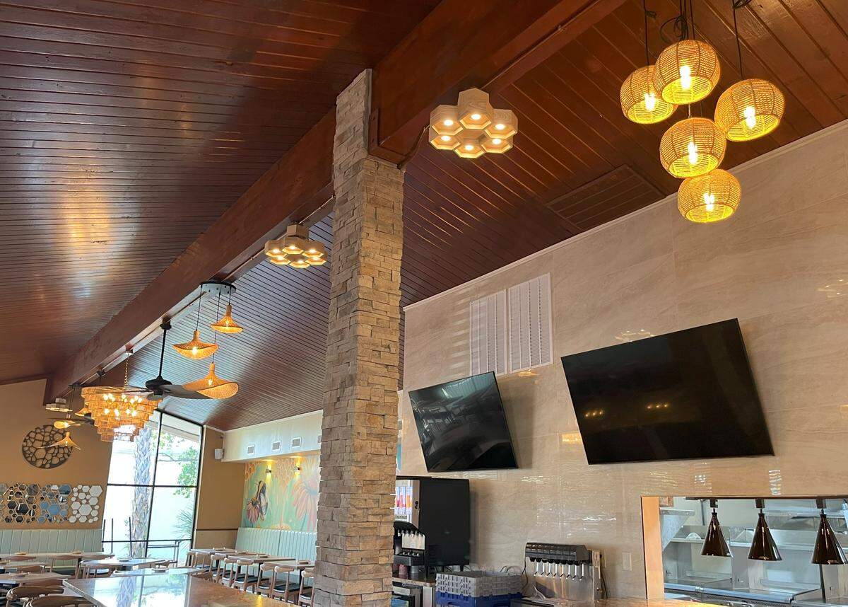 Honeycomb shaped lights and mirrors hang off the walls and ceiling of Salt and Honey’s dining room and bar. May 21, 2025.