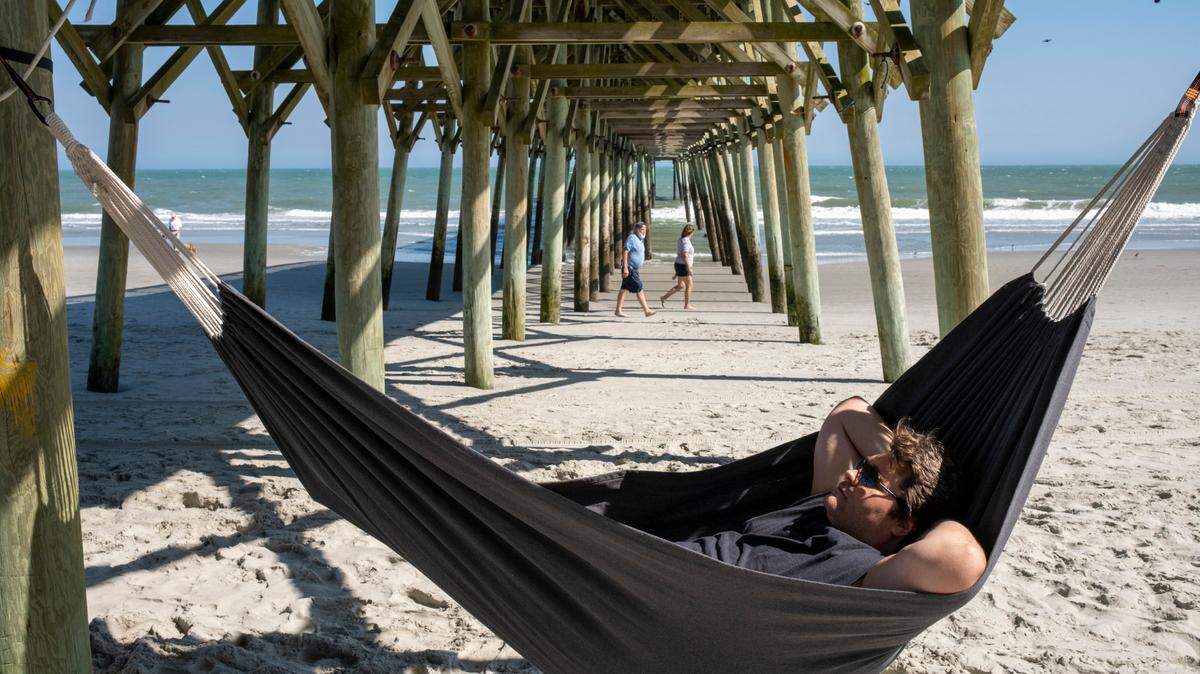 A local man relaxes in a hammock under the pier in Garden City Beach, S.C. March 24, 2023.