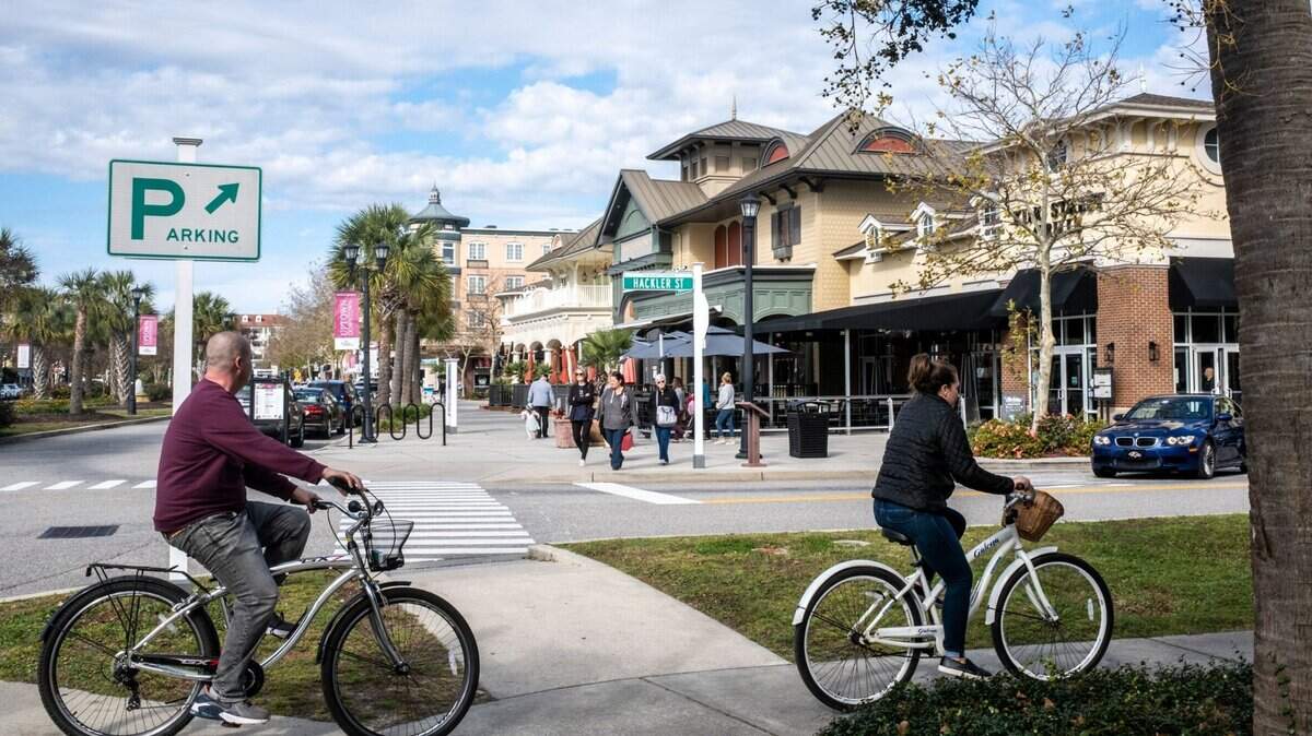 Cyclists ride past the central shopping district in The Market Common community of Myrtle Beach. November 14, 2022.