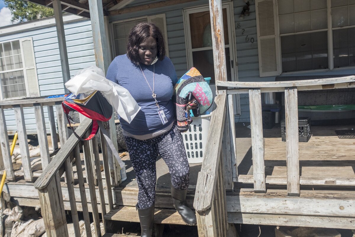 Desiree McCray takes belongings from her flooded home on Martin Luther Drive in Bucksport. The blanket under her left arm was an important keepsake that a local quilting group gave her when she was suffering through treatment for Lupus. Flooding along Bucksport Road finally receded enough on Wednesday for residents to get a first look at their flooded homes. Wednesday. October 3, 2018.