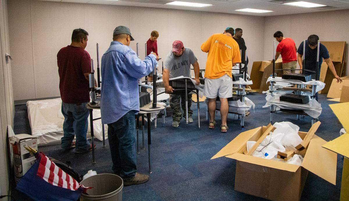 Crews work to assemble desks in a  modular classroom at St. James High School in Murrells Inlet Monday afternoon.