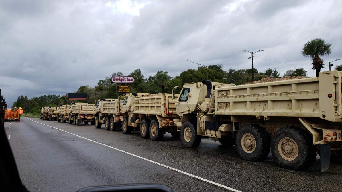 Several large trucks line U.S. 501 as officials prepare to construct a flood barrier to protect the highway from Hurricane Florence floodwaters.