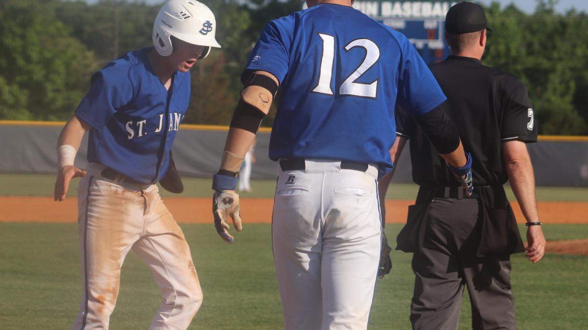 Jacob English, left, is congratulated after scoring a run by teammate Trystan Freeman during St. James High's game against Chapin on Wednesday night.