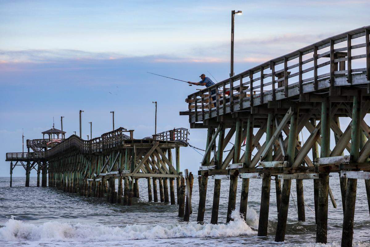 A fisherman casts from the broken Cherry Grove Pier in North Myrtle Beach, S.C. Myrtle Beach area piers took a battering from Hurricane Ian this year but a strong pier culture prevails drawing fisherman and tourist back year after year. October 12, 2022.