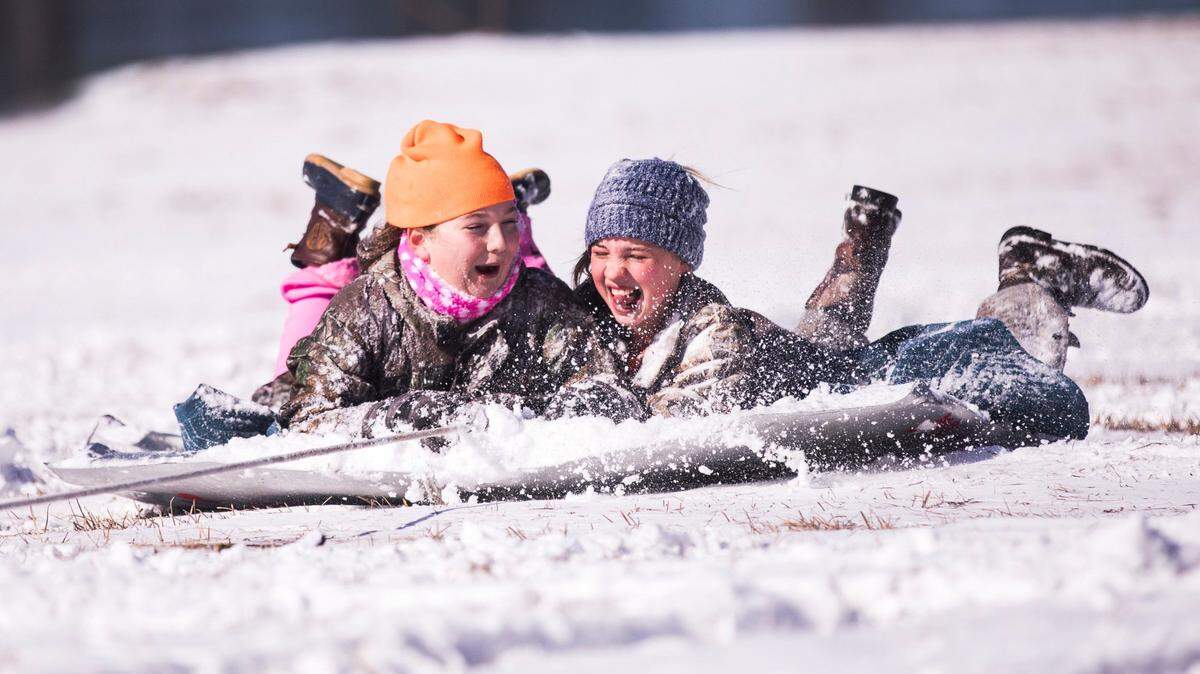 Savannah Gerald and Meredith Harrelson, both age 11, were pulled on an old car hood through the snow by a 4-wheeler driven by Chuck Harrelson at his farm outside Aynor on Thursday. While much of the Grand Strand missed the heaviest snowfall from Winter Storm Grayson, residents of Aynor woke up to over three inches of snow on Thursday. Jan. 4, 2018.