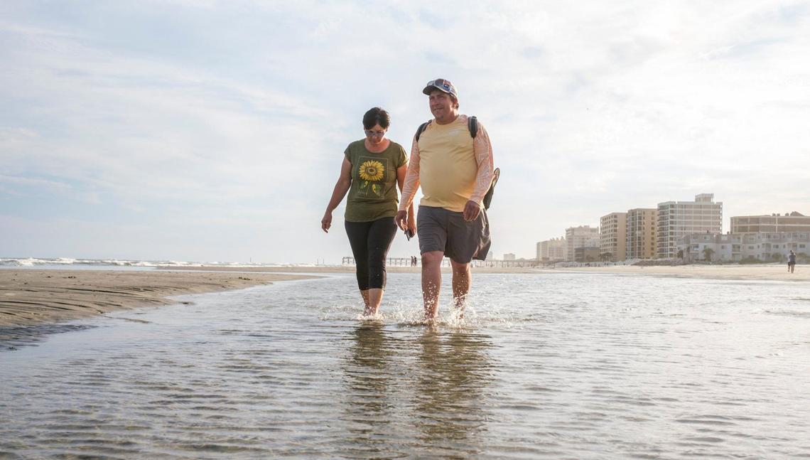 Eric and Alla Hawk of Monks Corner, S.C. walk through a tidal pool at Cherry Grove Point. The couple, on their third anniversary, enjoy the relative quiet of this section of strand. Beach goers enjoy the sand bars and tidal pools at the tip of Cherry Grove in North Myrtle Beach, S.C. The area, also known as Cherry Grove Point, has sand bars and tidal pools exposed during low tide. June 12, 2024.