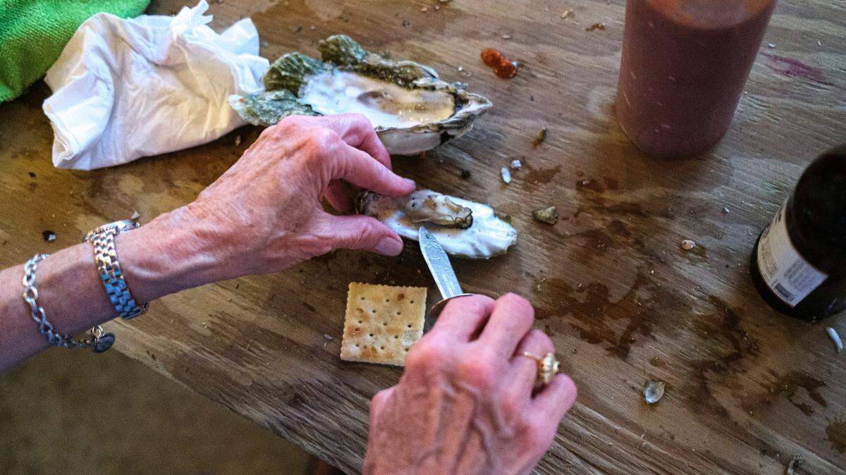 An oyster is carefully removed from it’s shell and placed on a saltine cracker with tobasco sauce, one of the many ways customers enjoy oysters. Here is where to find $1 oysters across the Grand Strand. Oct. 8, 2021.