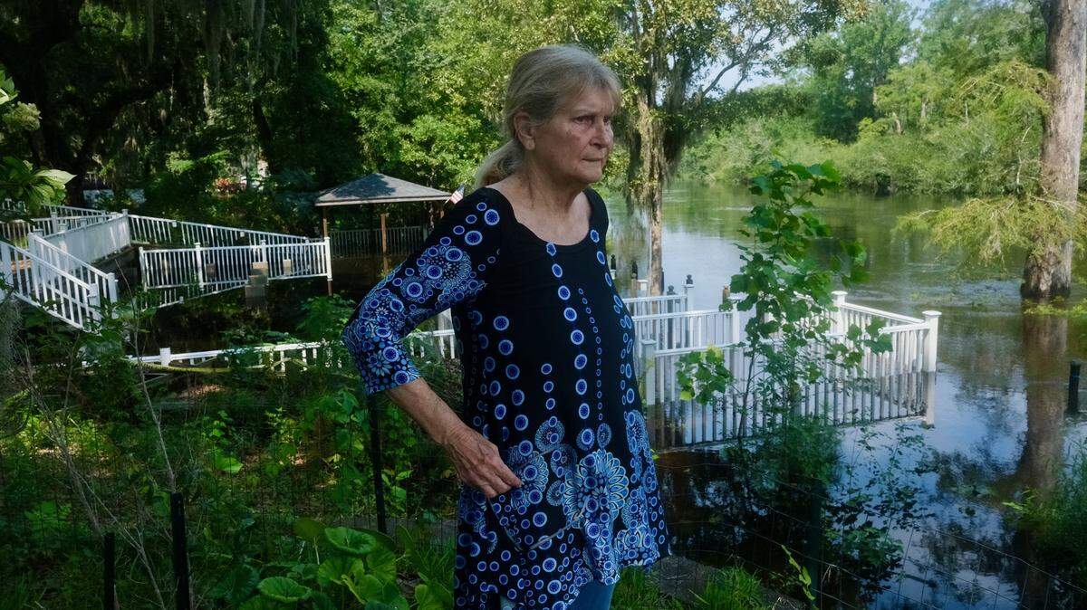 Saundra Watts Barnhill stands next to the Waccamaw River on her property along Star Bluff Road. One of Barnhill’s family member’s built the deck behind her which has gone underwater as the Waccamaw River floods due to rain from Tropical Storm Debby.