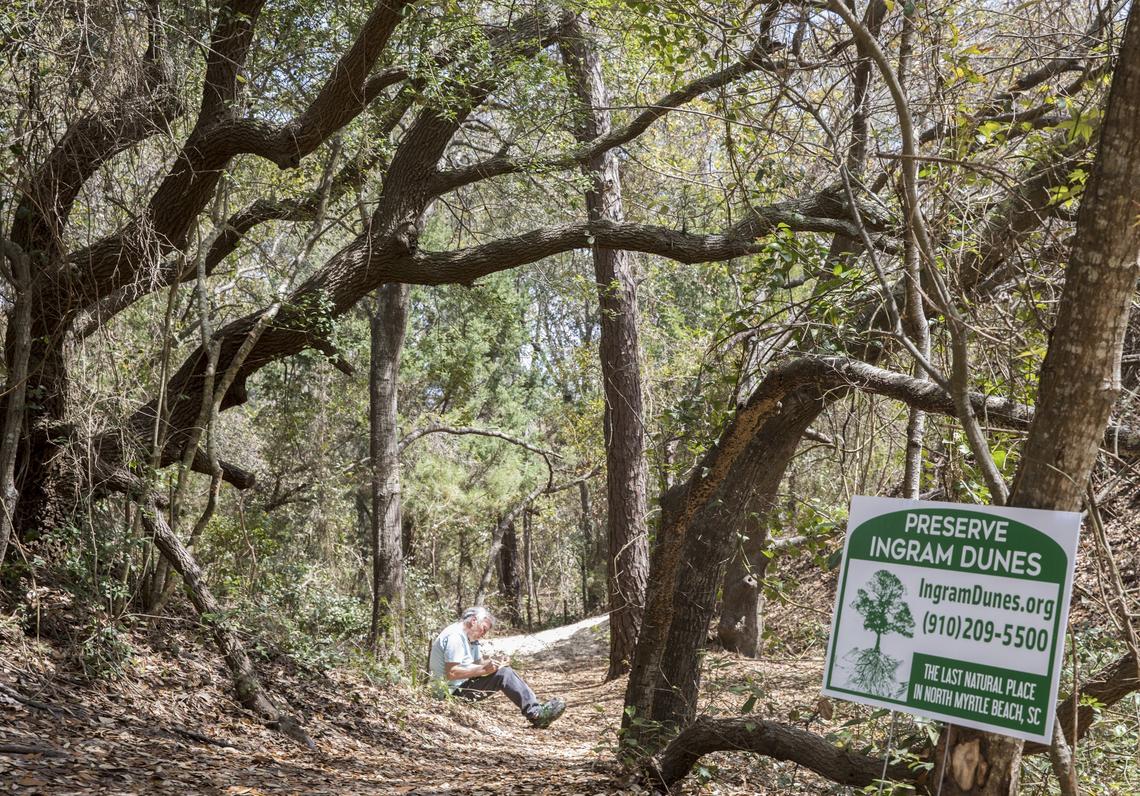 Damien Triouleyre with the Preserve Ingram Dunes group works his phone in an effort to raise support to protect the property from future development. April 2, 2018.