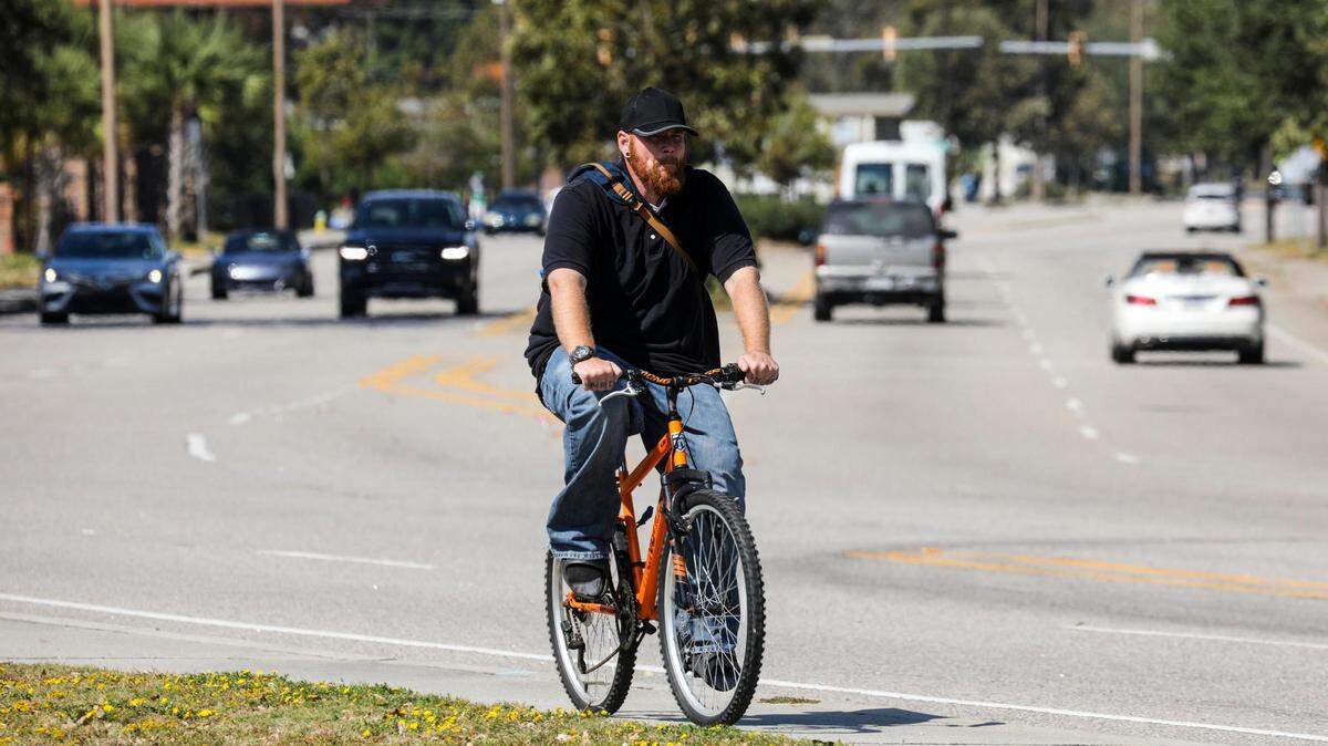 A bicyclist rides down the sidewalk along Mr. Joe White Avenue in Myrtle Beach. The South Carolina Department of Transportation plans to add pedestrian crosswalks, bicycle lane markings and additional safety improvements to the roadway after many accidents have occurred along the busy corridor. October 11, 2022.