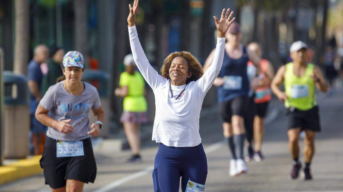 Bisceglia Gaston of Fayetteville, N.C. raises her hands and face to the sun as she and other runners are cheered by fans on Ocean Boulevard during the 25th Myrtle Beach Marathon that was held Saturday. Approximately 4.500 runners participated in the full marathon, half marathon and 5K races. . March 05, 2022.
