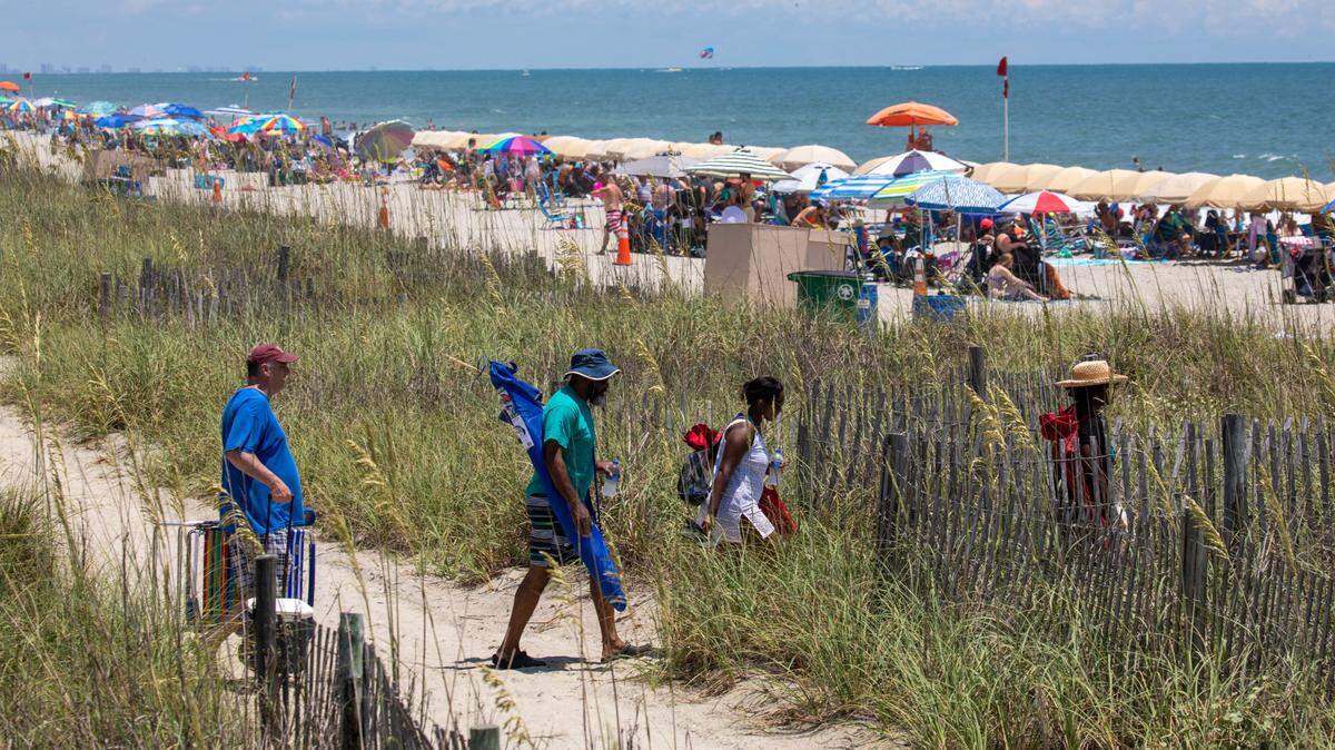 Tourists cross to a crowded Myrtle Beach. In the summer heat of July, Myrtle Beach area residents and tourists look to the water for relief. With waterparks, jet ski rentals, parasails, banana boat rides, paddle boards and kayaks, there are plenty of options to beat the heat. July 5, 2022.