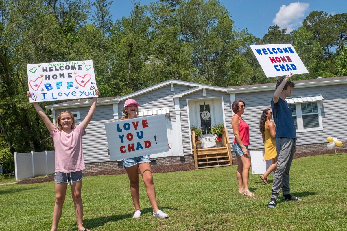 Family and friends hold signs celebrating Chad Hardee’s return home after nearly six months of hospitalization. His continued recovery from the virus has been called a miracle by his family and friends. May 28, 2021.