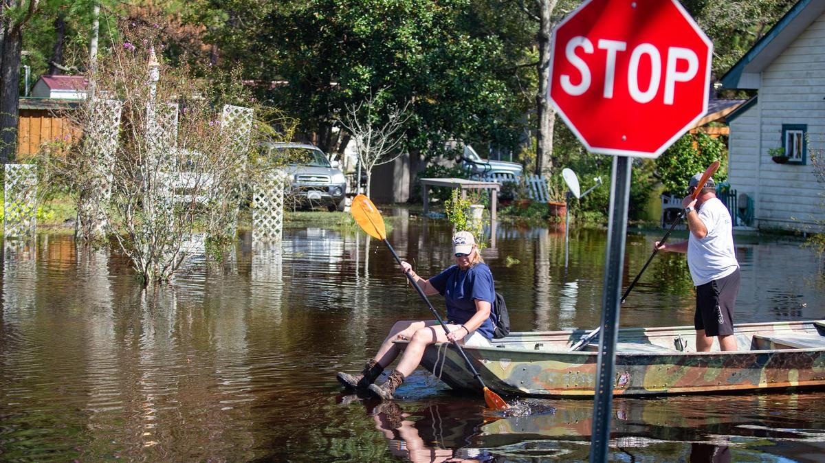 Star Bluff Road residents Jay and Cessa Davis paddle a jon boat into their neighborhood as they assess damage done by the flood waters of Hurricane Florence.
