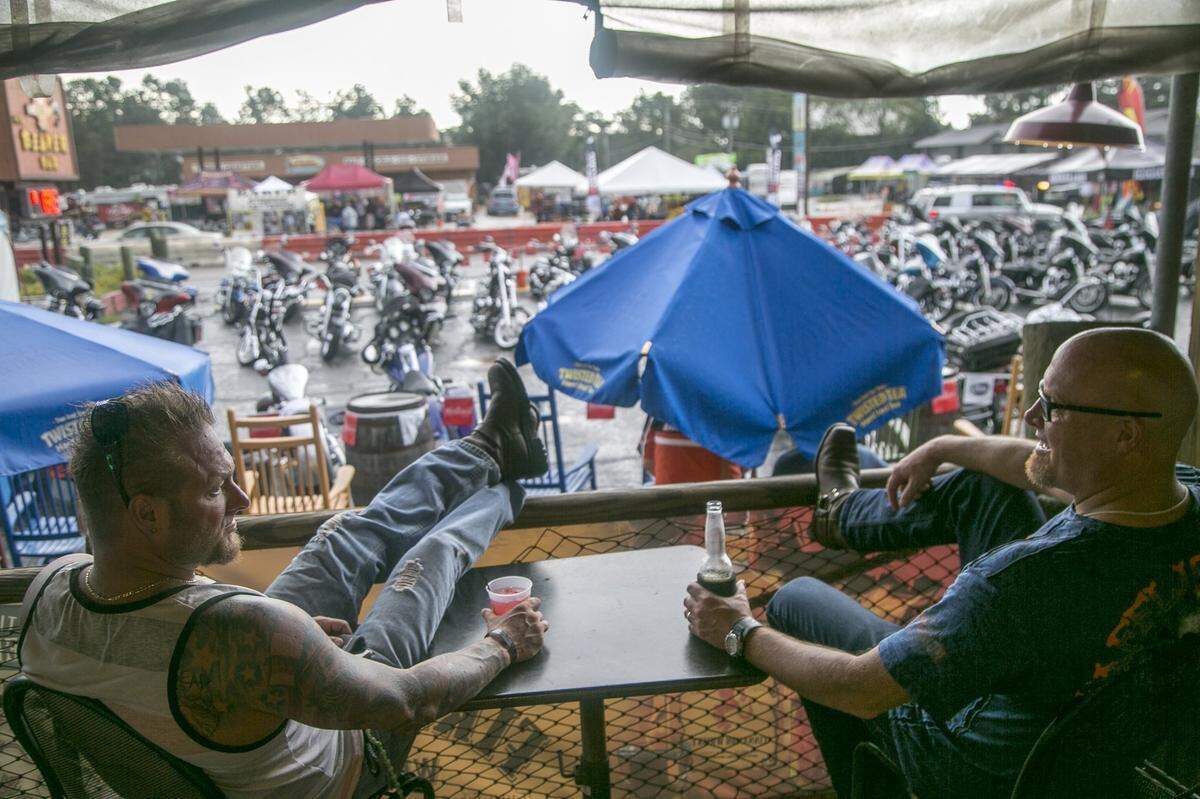 Pete McCann and Brett Newman kick back on the porch of the Beaver Bar and watch their fellow bikers go by in the rain. The Fall Bike Rally is being held this week. Rainy conditions may have contributed to smaller crowds at popular Murrells Inlet hot spots on Wednesday.