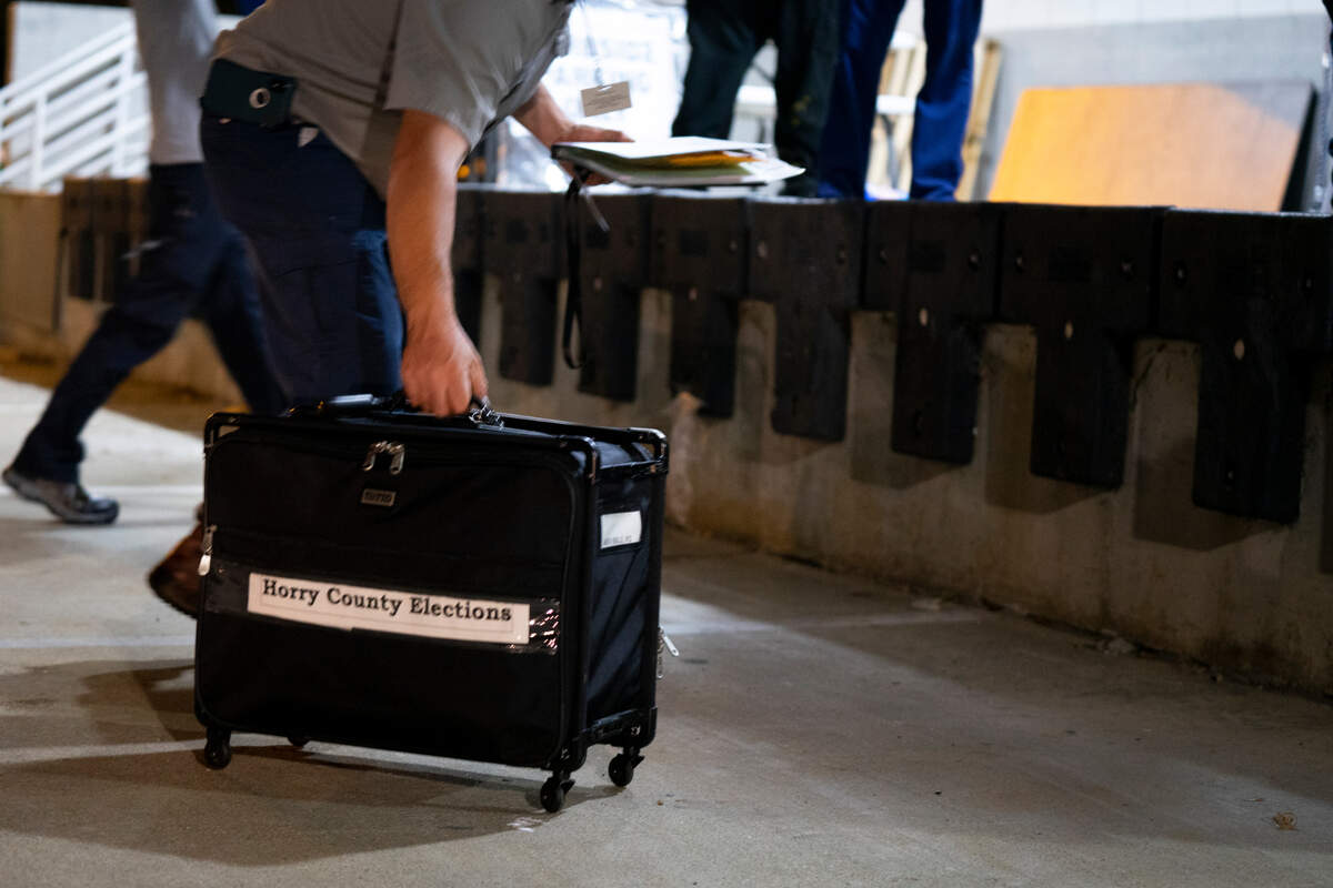 Horry County crews work to unload ballot boxes from cars around 8 p.m. on election night. They are delivered from precincts and loaded into the Elections office.