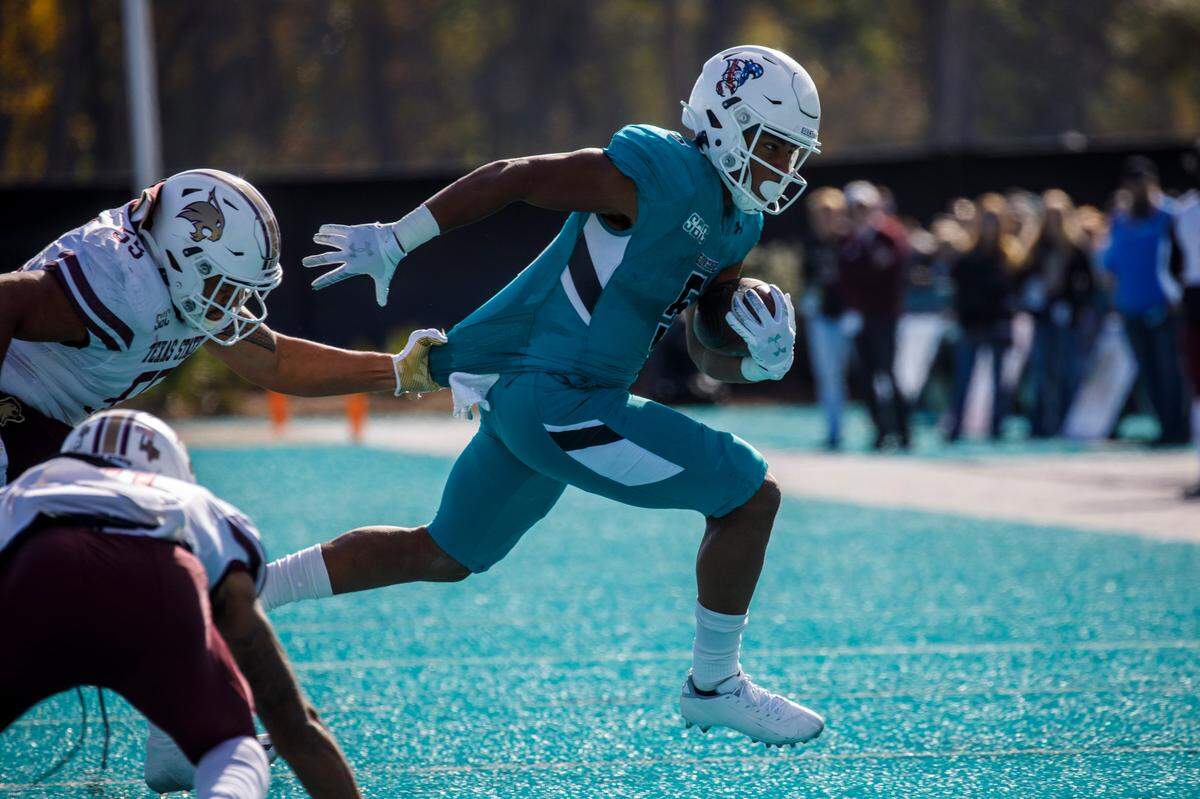 Coastal Carolina’s Shermari Jones dodges Texas State defenders in Conway SC. Nov. 20, 2021.