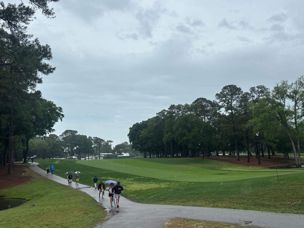 Myrtle Beach Classic PGA Tournament attendees walk through the rain Sunday afternoon.