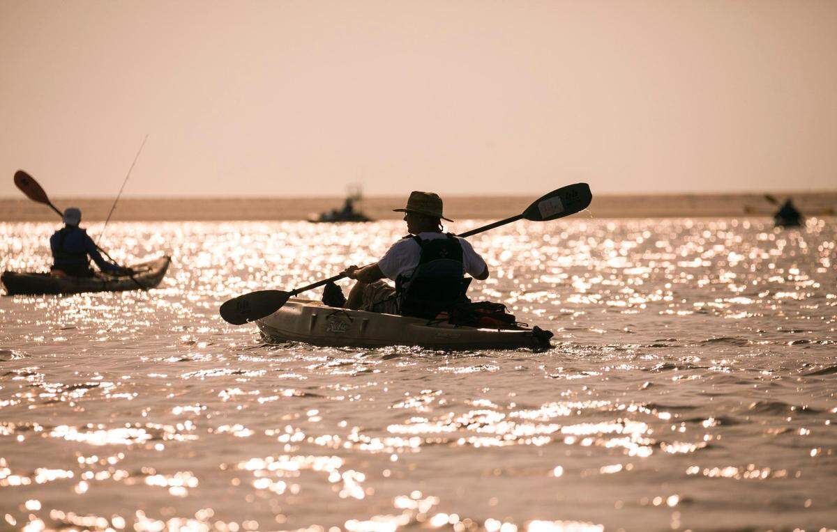 Clients of Yak Outdoor Guides paddle their kayaks across Midway Inlet just after sunrise in Pawleys Island. File photo. July 1, 2019.