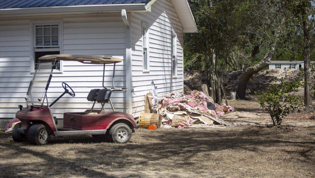 Piles of carpet and insulation lie on the ground outside of Rodney and Angel Hyman’s home in Marion County Tuesday. The Hymans built a 6-foot-deep moat and an 8-foot-high dirt mound all around their house to protect their home from floodwaters. Water still breached the home, according to Hyman’s sister-in-law Dessie Hyman.