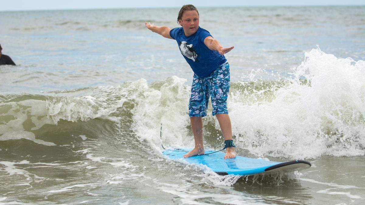 Volunteers helped Charlie Monroe, 11, learn how to surf during Take A Kid Surfing Day in North Myrtle Beach on Aug. 7, 2021.