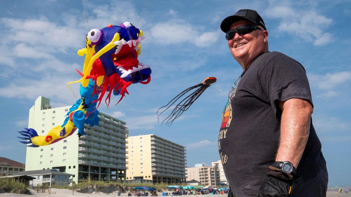 Dale Dove, of Rock Hill, South Carolina, flies some of his kites in the Cherry Grove section of North Myrtle Beach, S.C. as kids play below and beachgoers admire them. Dove, who grew up in the area, has more than 80 kites and frequently flies them when he comes to visit his mother in North Myrtle Beach, S.C. July 20, 2023.