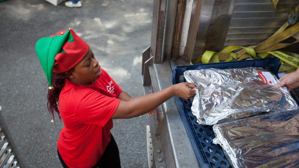 Alex Savage, who has been volunteering at he event since age 12, loads food into a refrigerator truck. For 25 years, The Red Cross of Myrtle Beach has served Christmas Dinner to those in need. Since Monday, throngs of volunteers have been furiously working to prepare for the thousands of mouths that will be fed.