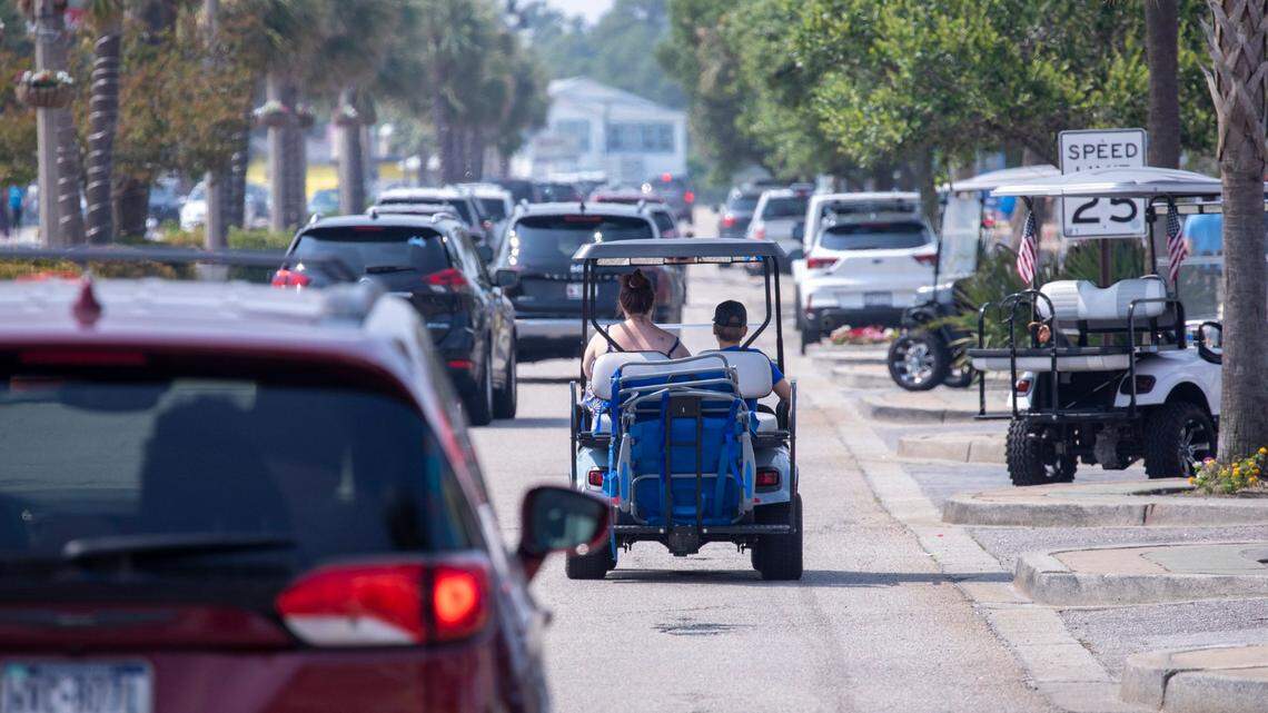 Golf carts navigate traffic on Main Street in North Myrtle Beach, S.C. June 9, 2023.