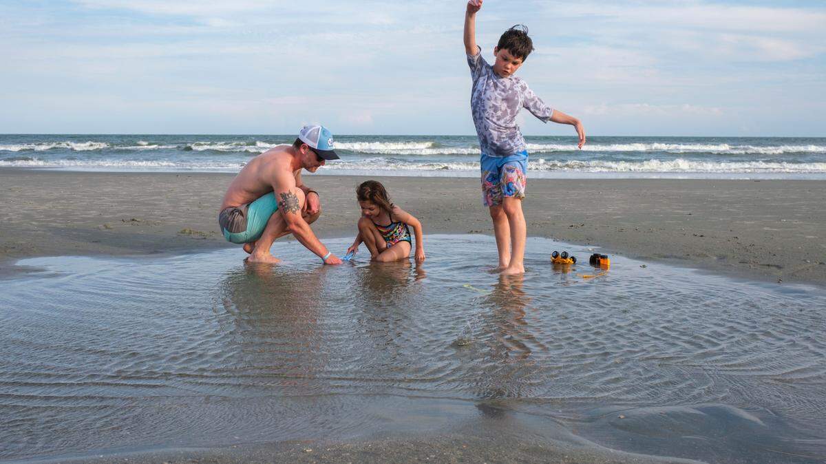Jeff Williams plays with his children Julia, age 5, and Jude, age 9, in a tidal pool. June 12, 2024.