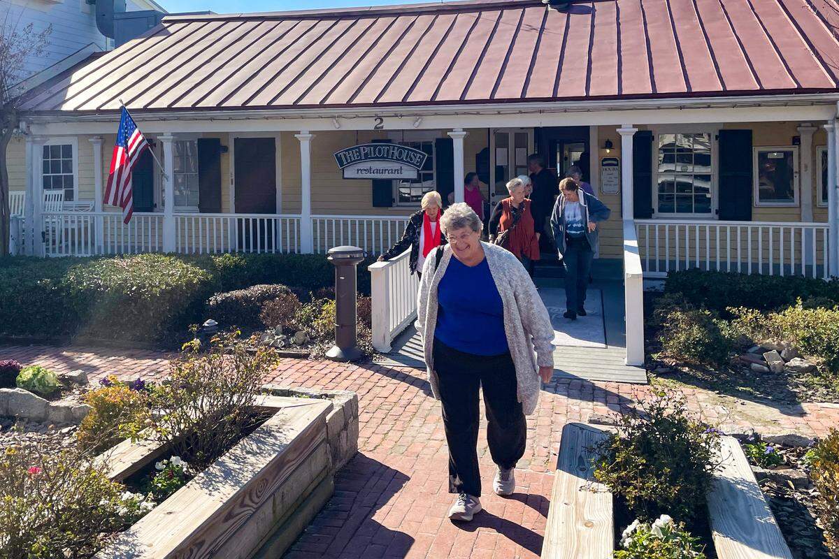 Kofie Montgomery, front middle, walks out of the Pilot House restaurant in Wilmington, N.C. where she had lunch with 10 other people as part of Senior Adventures in Learning and Travel. Afterwards, the group went to the local Trader Joe’s to stock up on food from the popular grocery store.