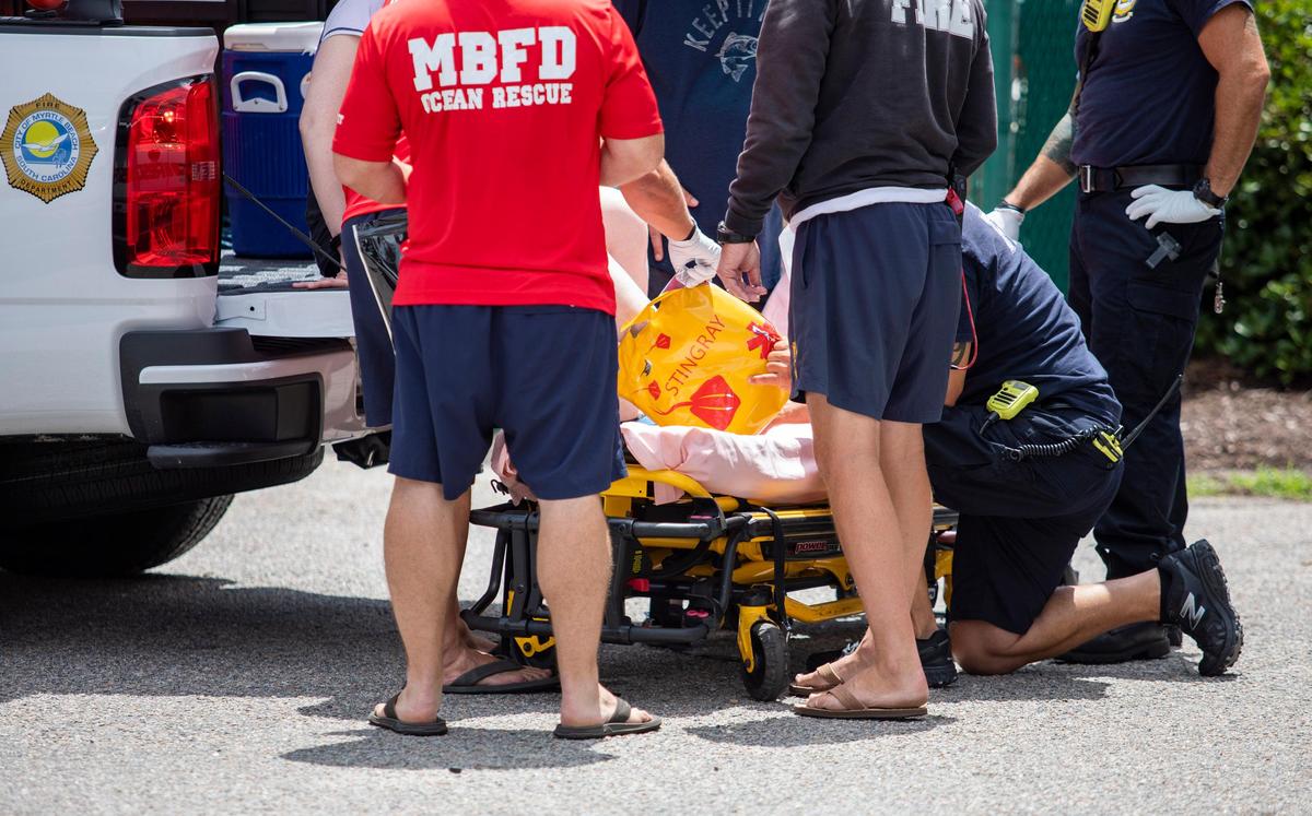 Myrtle Beach Fire Rescue members treat a woman for a stingray sting at the beach access for 24th Avenue N. in Myrtle Beach Thursday afternoon.